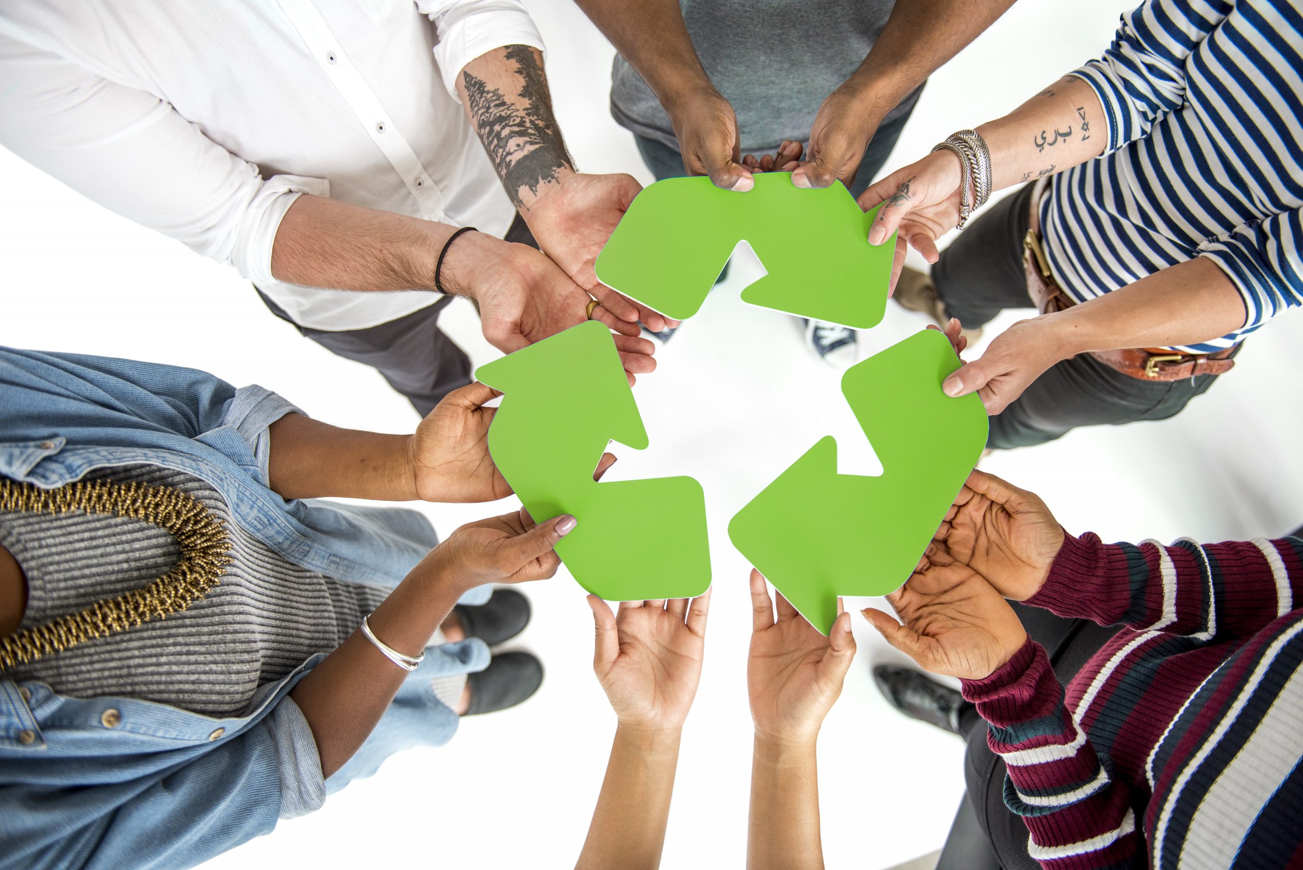 Groupe de personnes qui tiennent le symbole du recyclage lors d'un événement