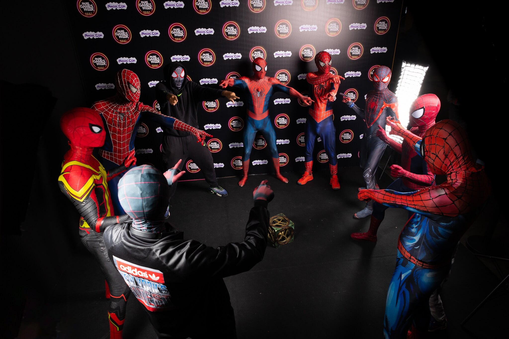 Photo Cosplay où on voit 9 spiderman en rond. En référence au metavers.
