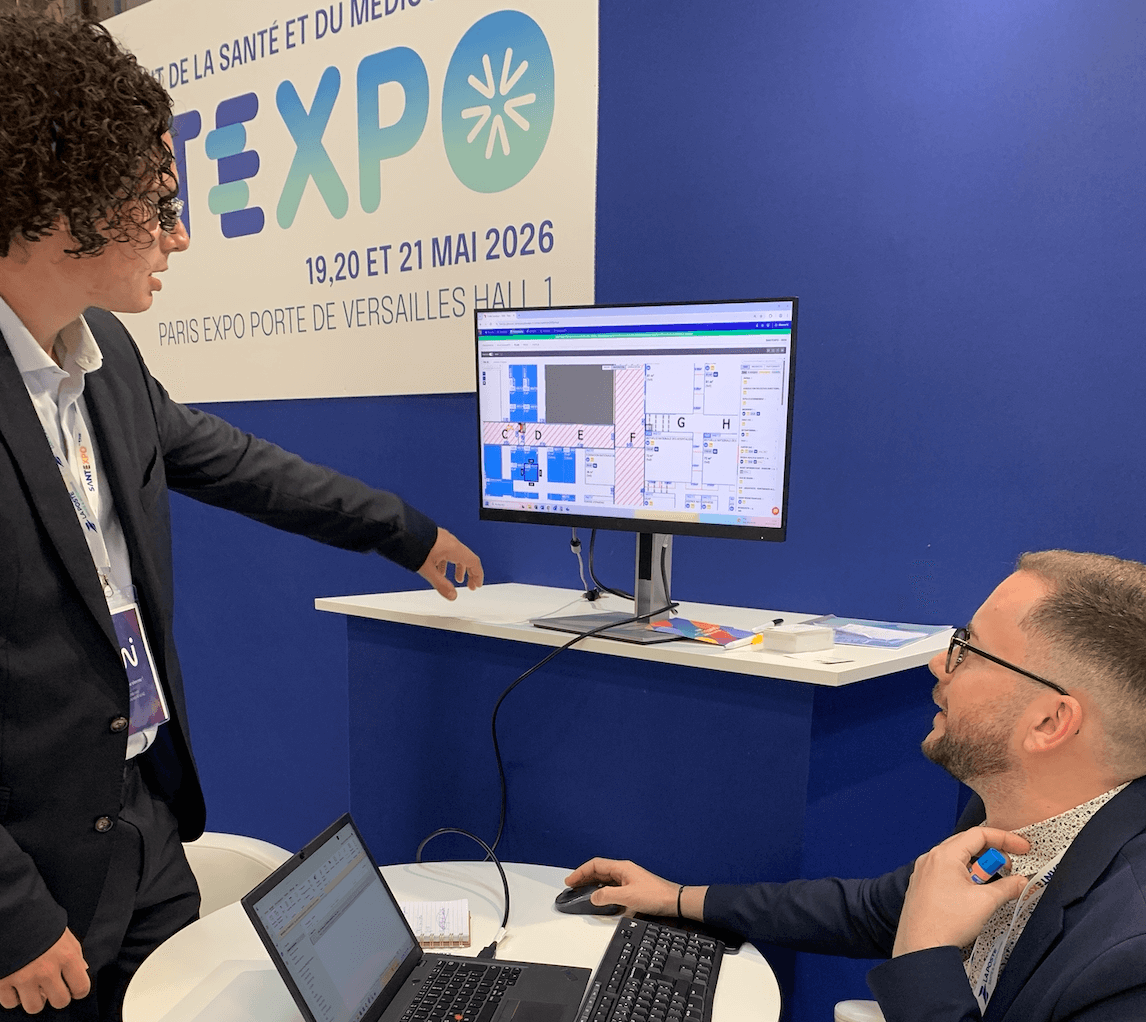 Négociation en cours sur le stand du rebooking de Santexpo - on y voit le plan commercial, un exposant et le commercial de l'événement